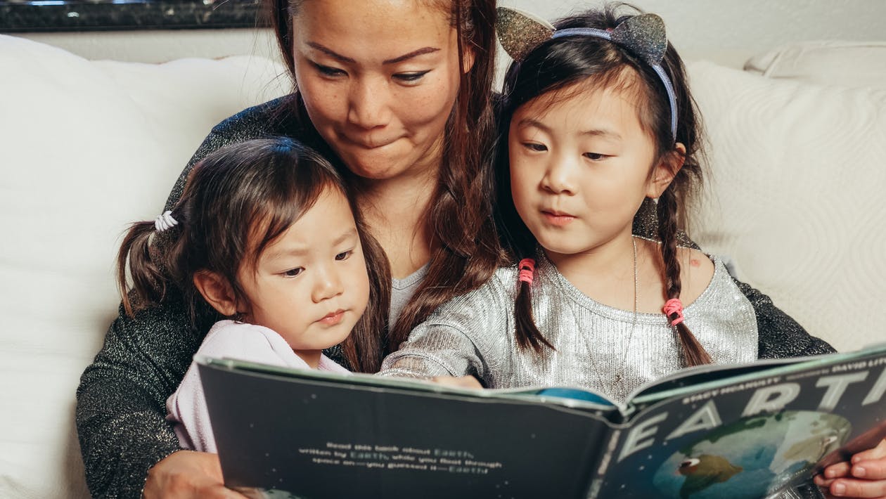 anak perempuan dan ibu membaca buku